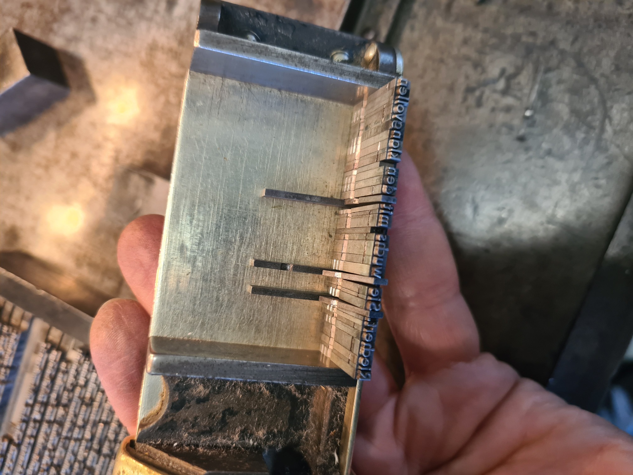 Winkelhaken in einer Hand, auf diesem Bleisatz.